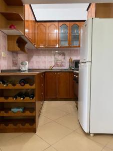 kuchnia z białą lodówką i drewnianymi szafkami w obiekcie Marl's Home w mieście Berat