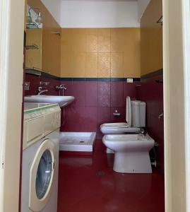 a bathroom with two toilets and a washing machine at Marl's Home in Berat