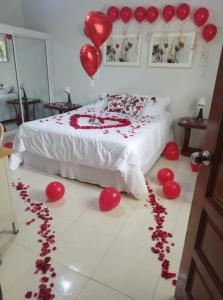 Habitación con cama con globos rojos y corazones en el suelo en CASITA HOGAREÑA JARABACOA (independent entrance), en Jarabacoa