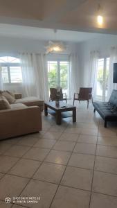 a living room with couches and a table and windows at Eva's house in Kánithos
