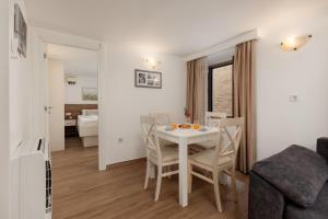 a dining room and living room with a table and chairs at Apartment Amigo Old Town Kotor in Kotor
