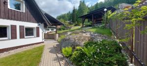 Ubytování Na Výsluní Tanvald في تانفالد: منزل وصخرة بجانب مبنى
