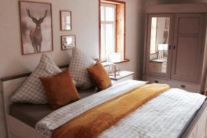 um quarto com uma cama com almofadas e uma janela em Landhaus Weserbergland - Rosel em Vahlbruch