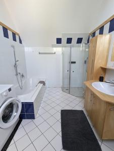 a bathroom with a tub sink and a washing machine at Bonito - Historischer Streckhof in Schützen am Gebirge