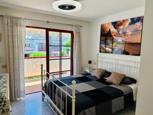 een slaapkamer met een bed en een groot raam bij Playa del Cura in Playa del Cura