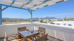 a table and chairs on a balcony with a view at Elements of Milos in Mytakas