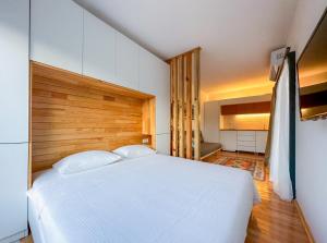 una camera con letto bianco e testiera in legno di Gümüşlük No3 a Bodrum City