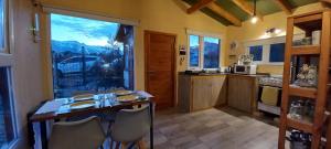 une cuisine avec une table et des chaises ainsi qu'une grande fenêtre dans l'établissement Casa con hermosa vista a los cerros, à San Carlos de Bariloche