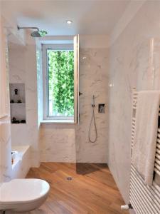 baño con ducha y aseo y ventana en Viaemilia Alessandria, en Alessandria