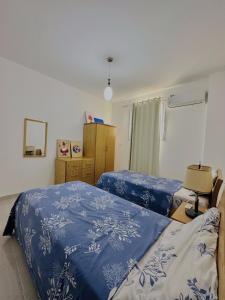 1 Schlafzimmer mit 2 Betten mit blauer und weißer Bettwäsche in der Unterkunft Luxor Rose Villa in Luxor