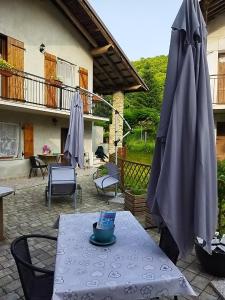 盧里西亞的住宿－Il Ciliegio di Lurisia，桌子、雨伞和桌椅