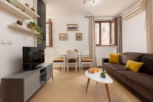 a living room with a couch and a tv and a table at Apartment Amigo 2 Old Town Kotor in Kotor