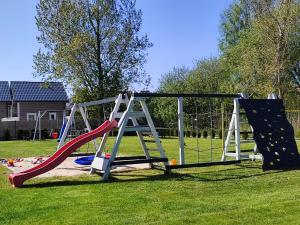 a playground with a slide and a climbing frame at Lazur Resort in Rogowo