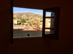 uma janela com vista para uma piscina e para as montanhas em Holâ Hotel em La Falda