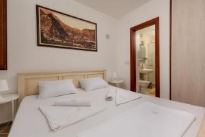 a bedroom with a white bed with a picture on the wall at Apartment Amigo 2 Old Town Kotor in Kotor