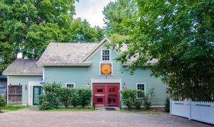 a blue house with a red door and trees at Heart of the Village Bed & Breakfast in Shelburne VT in Shelburne