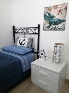 una camera con letto blu e comodino di A Casa di Nadia a Lido Conchiglia