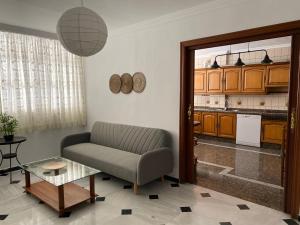 a living room with a chair and a kitchen at En playa, céntrico y acogedor in Fuengirola