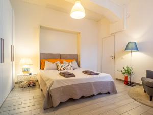 a bedroom with a large bed and a chair at Loveflat - scopri Ferrara in bicicletta in Ferrara