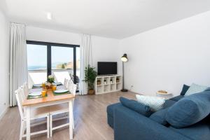sala de estar con sofá azul y mesa en Nuevo Atico Panoramico - Piscina - 3 habitaciones - Terraza vista Mar, en Rincón de la Victoria