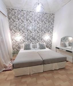 um quarto com uma cama e uma parede floral em Johnny's loft 2 em Agrinio