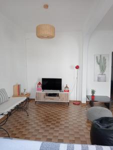 sala de estar con TV de pantalla plana en una pared blanca en Bluemoon Campinho (Alqueva) en Campinho