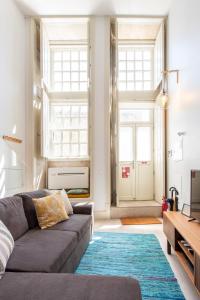 a living room with a couch and a blue rug at Casa Barros - Miragaia in Porto