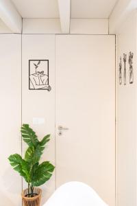 a bathroom with a shower and a potted plant at Casa Barros - Miragaia in Porto