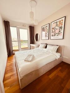 1 dormitorio con 1 cama grande y 2 ventanas en Jardin Apartment Ursynów, en Varsovia