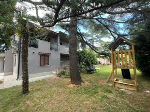 a wooden swing set in the yard of a house at Flowers Apartments Medulin, Fucane 2 in Medulin