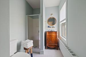 La salle de bains est pourvue d'une douche, d'un lavabo et d'un miroir. dans l'établissement Atlantic Inn, à New Shoreham