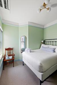 a bedroom with a large bed and a chair at Atlantic Inn in New Shoreham