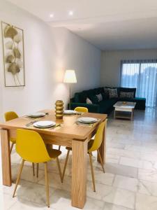 - un salon avec une table en bois et des chaises jaunes dans l'établissement Appartement de luxe,au Cœur de casa, à Casablanca
