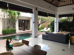 a living room with a couch and a table and a pool at Villa Krishna in Canggu