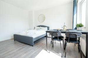 sypialnia z łóżkiem, stołem i krzesłami w obiekcie Gemütliche 2-Zimmer-Wohnung w mieście Neustadt in Holstein