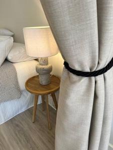 1 dormitorio con 1 cama y 1 mesa con lámpara en Nissaki@Terrigal - Luxury Studio Apartment en Terrigal