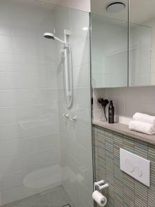 a bathroom with a shower with a glass door at Nissaki@Terrigal - Luxury Studio Apartment in Terrigal