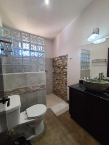 a bathroom with a toilet and a sink at Guest House with Shared Pool Access in David