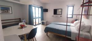 a bedroom with a bed and a table and a table and a bed at Pedras d'el Rei - Casa Mira in Tavira
