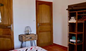 Cette chambre dispose d'une porte en bois et d'une étagère. dans l'établissement Bas de villa vue mer & piscine, à Coti-Chiavari