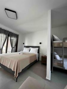 a bedroom with a large bed and two bunk beds at •Naiades Villas•Meliti• in Ladharió