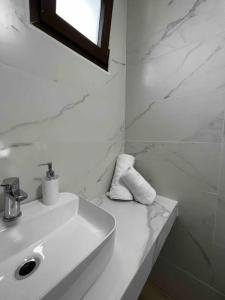 a white bathroom with a sink and a mirror at •Naiades Villas•Meliti• in Ladharió