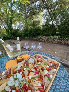 una bandeja de comida en una mesa con copas de vino en Suite avec jardin entre Aix en Provence, Luberon et Verdon, en Peyrolles-en-Provence