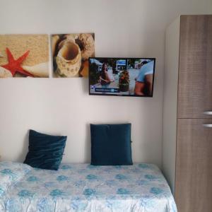 蒙德拉戈的住宿－Casa Margherita piano primo，卧室配有一张墙上有两张照片的床。