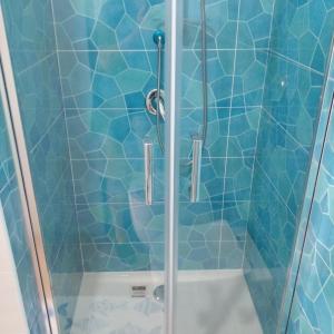 una doccia con porta in vetro in bagno di Casa Margherita piano primo a Mondragone