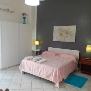una camera da letto con un letto rosa con due asciugamani di Casa Margherita piano primo a Mondragone