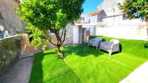 un pequeño patio con 2 sillas y un árbol en Bela Houses - Porto Center Garden 3, en Oporto
