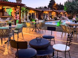 eine Terrasse mit Tischen und Stühlen und einem Pool in der Unterkunft Etiz Hotels Alaçatı in Cesme