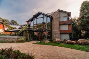 une maison avec de grandes fenêtres et une allée en briques dans l'établissement 249 DESIGN HOTEL, à Gramado
