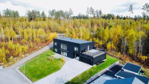 an aerial view of a black house in the woods at Villa Maitri in Alvesta